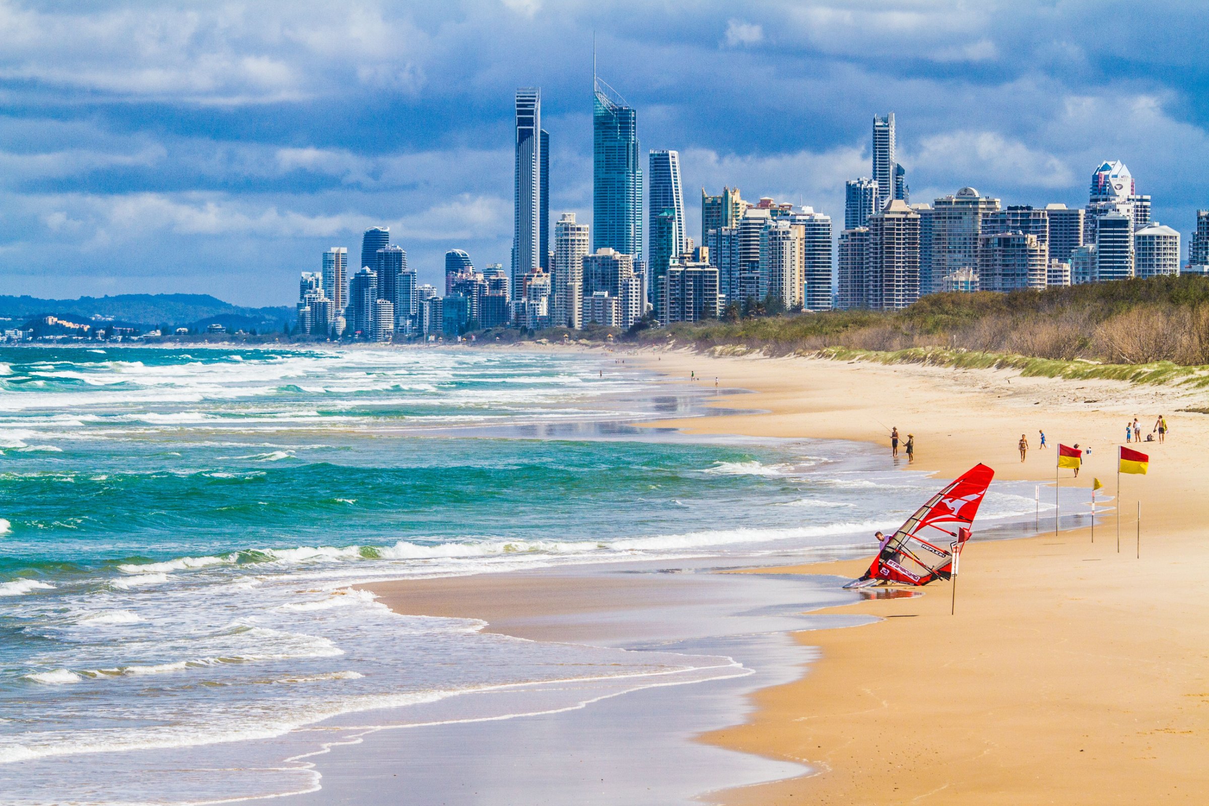 A patrolled surf beach on the Gold Coast with the city skyline behind