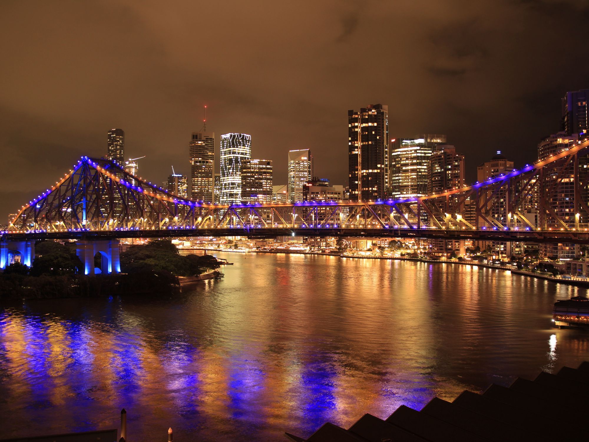 Brisbane's Story Bridge lit up at night over the Brisbane River