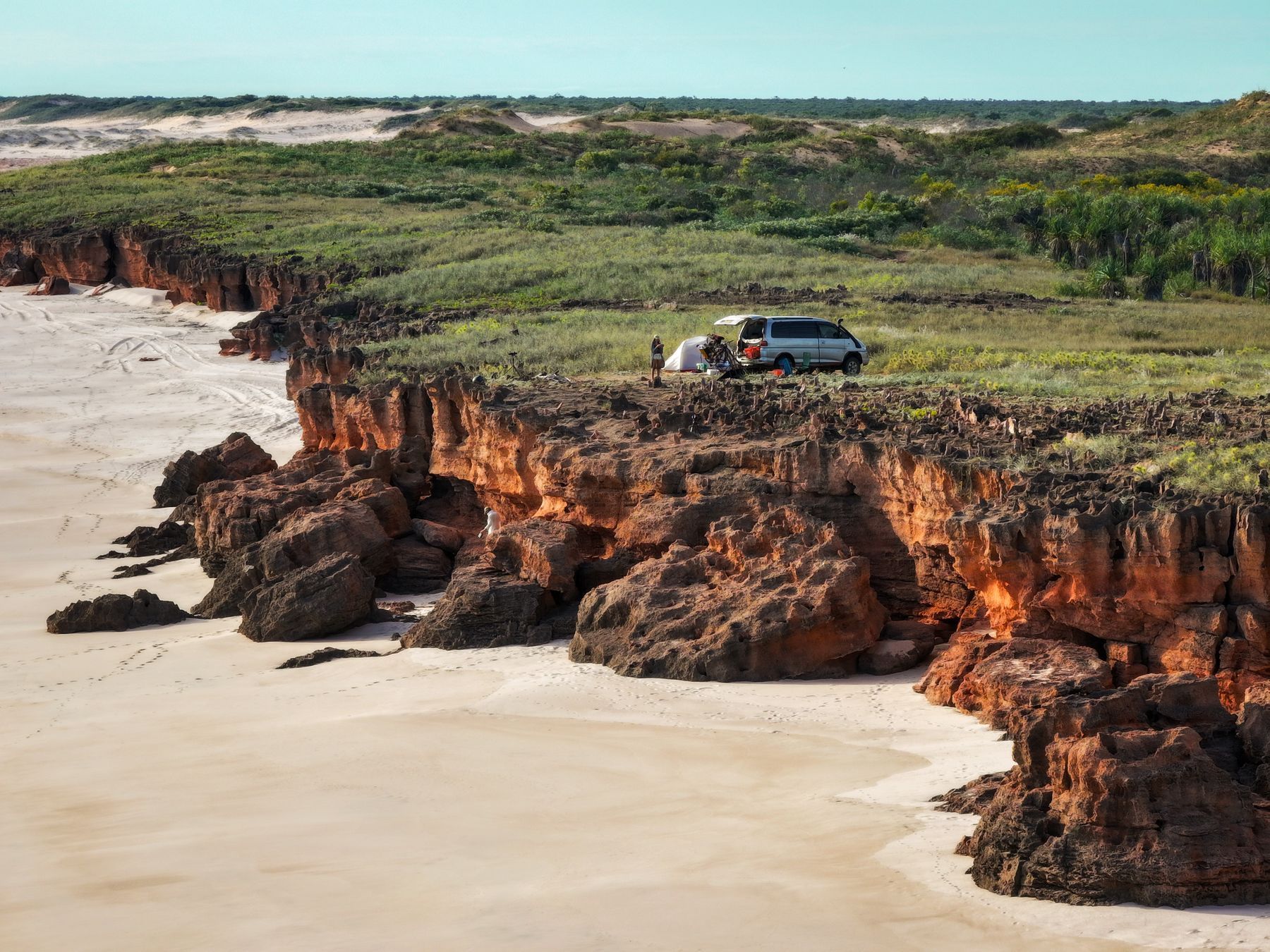 A campervan and tent on red cliffs on the Dampier Peninsula
