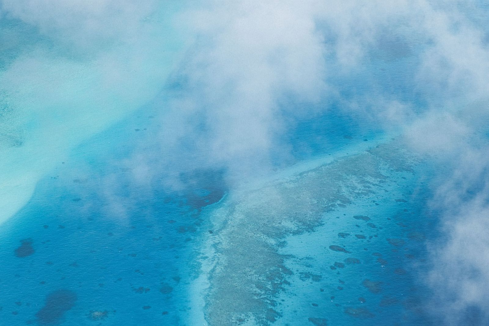 Reef shallows seen through the clouds from a plane